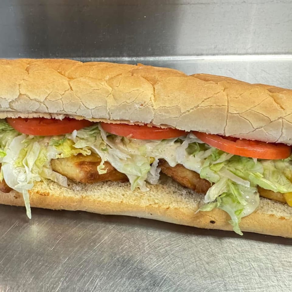 A Big's Pizza and Subs sub sandwich with fried chicken, lettuce, tomato, and sauce.