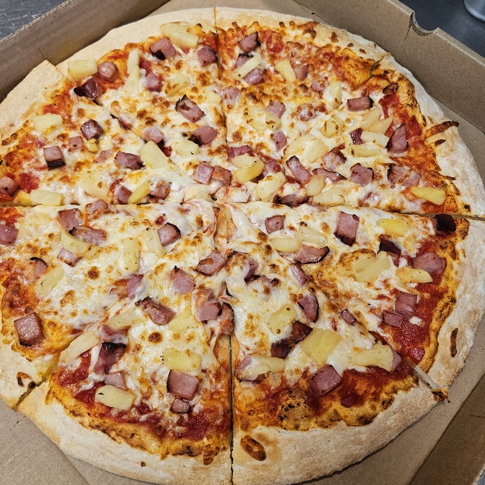 A Big's Pizza and Subs Hawaiian pizza with ham and pineapple in a cardboard box.