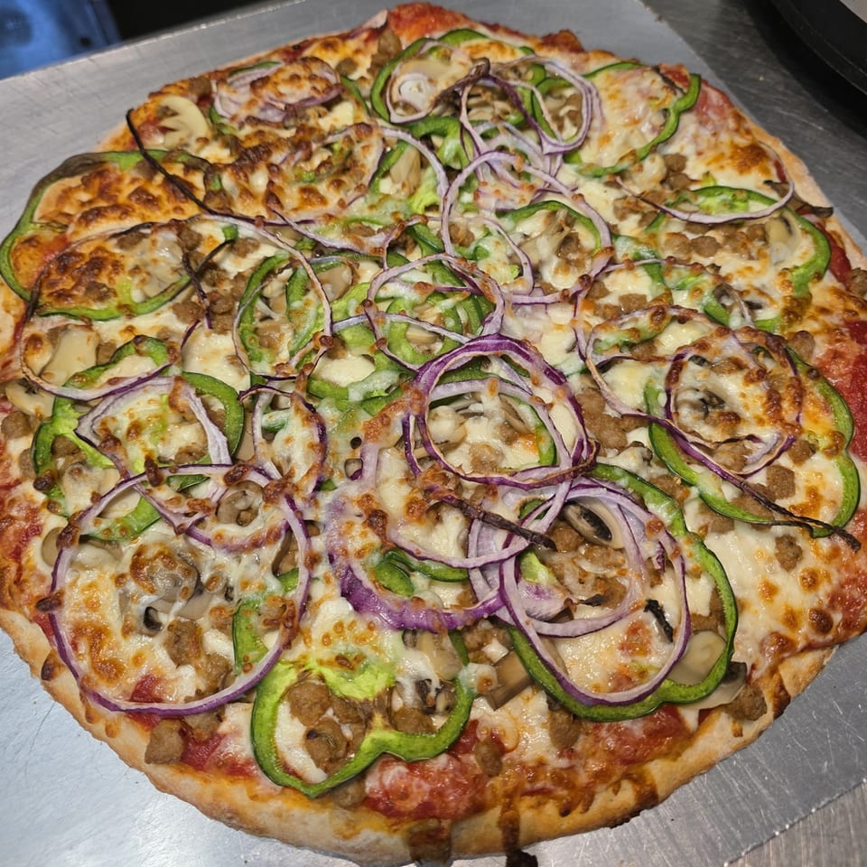 A Big's Pizza and Subs pizza with green peppers, red onions, mushrooms, and sausage.
